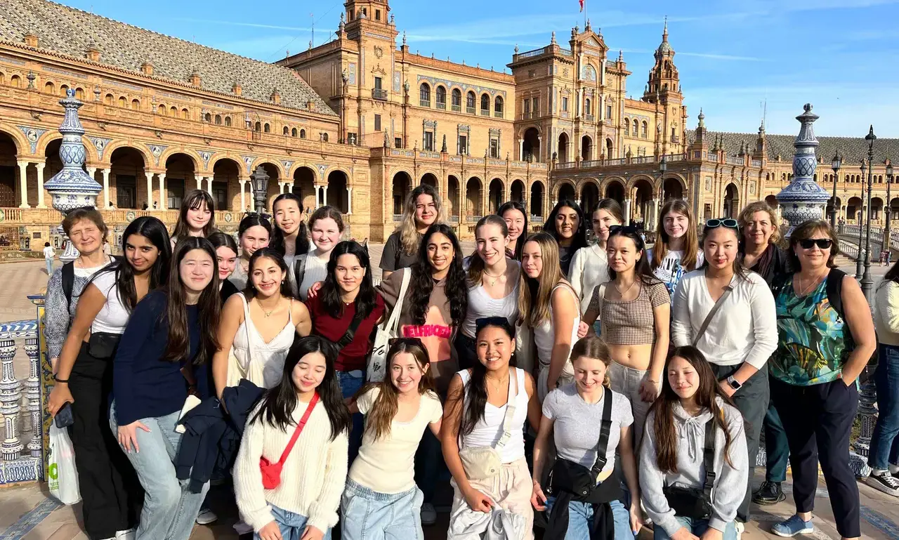 A group of students gathering in front of an architecture in Spain