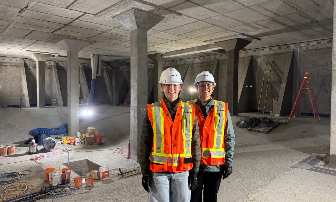 Two senior students wearing hard hats and reflective vest at a job site for work integrated learning