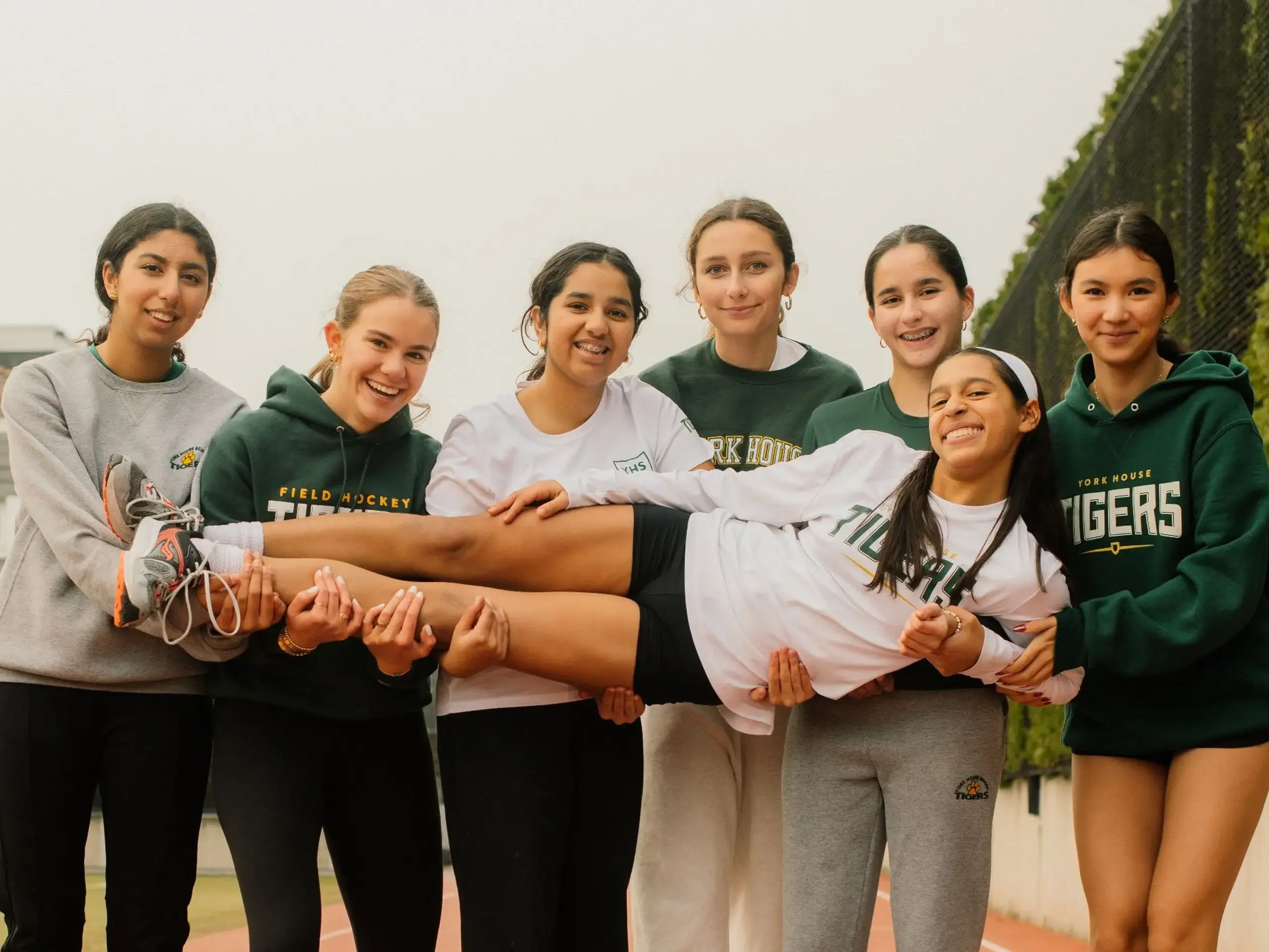 Group of Students on Track Holding one student across them